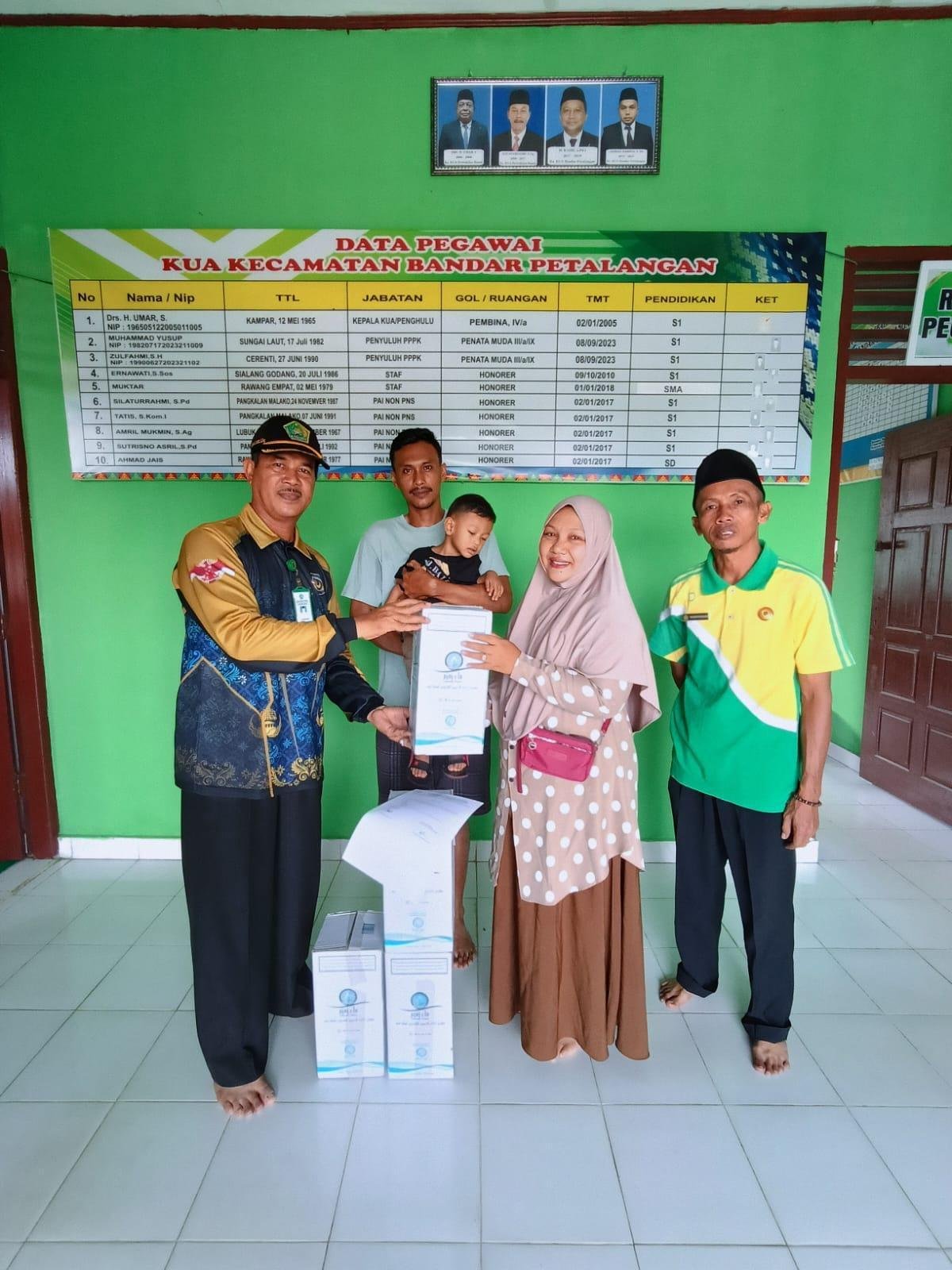Kepala KUA Bandar Petalangan Bagikan Air Zam-Zam untuk Keluarga Jamaah Haji